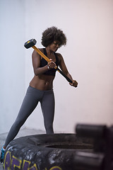 Image showing black woman workout with hammer and tractor tire