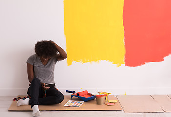 Image showing back female painter sitting on floor