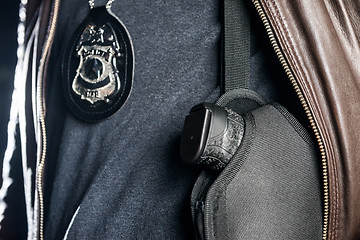 Image showing Closeup midsection of police officer with badge and gun in holst