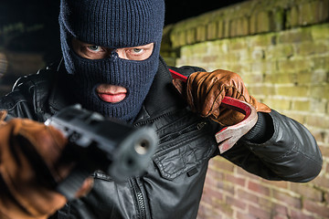 Image showing Portrait of serious masked gangster holding crowbar while pointi