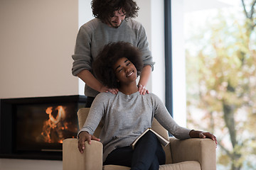 Image showing multiethnic couple hugging in front of fireplace