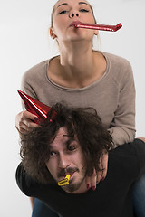 Image showing couple in party hats blowing in whistle