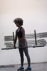 Image showing black woman lifting empty bar