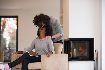 Image showing multiethnic couple hugging in front of fireplace