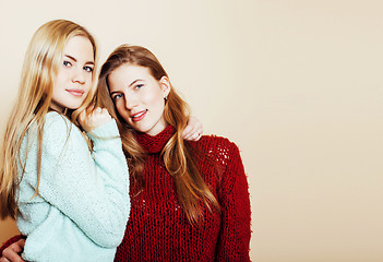 Image showing Two young girlfriends in winter sweaters indoors having fun. Lif