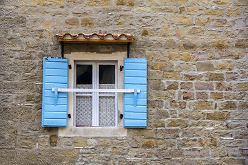 Image showing Blue wooden window shutters on the old stone house