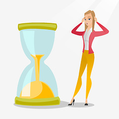 Image showing Desperate business woman looking at hourglass.