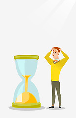 Image showing Desperate businessman looking at hourglass.