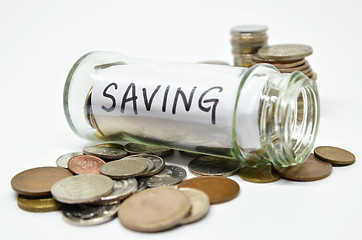 Image showing Saving lable in a glass jar with coins spilling out