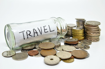 Image showing Travel lable in a glass jar with coins spilling out