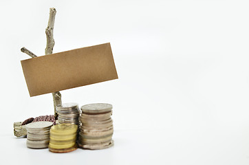 Image showing Paper sign board with stack of coins