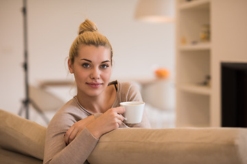 Image showing woman with a mug near a fireplace