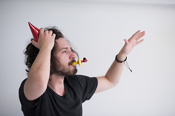 Image showing Portrait of a man in party hat blowing in whistle