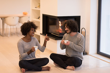 Image showing multiethnic couple  in front of fireplace