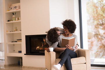 Image showing multiethnic couple hugging in front of fireplace