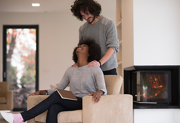 Image showing multiethnic couple hugging in front of fireplace