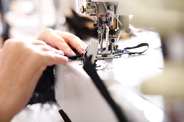 Image showing Seamstress sewing on the sewing machine in the manufacturing plant 