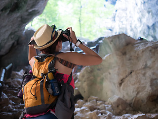 Image showing Brunette with camera among rocks