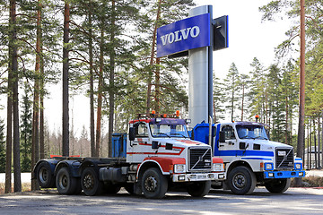 Image showing Two Conventional Volvo N12 Trucks under Volvo Sign