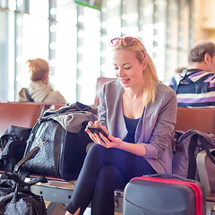 Image showing Female traveler using cell phone while waiting on airport.