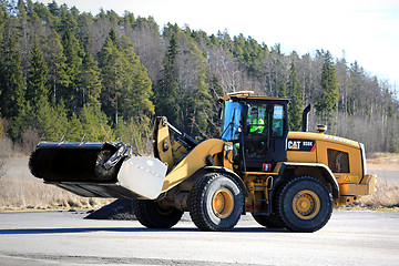 Image showing Cat Wheel Loader Bucket Sweeper Cleans Yard at Spring 