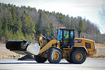 Image showing Cat Wheel Loader Bucket Sweeper Cleans Yard