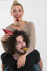 Image showing couple in party hats blowing in whistle