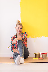 Image showing young female painter sitting on floor