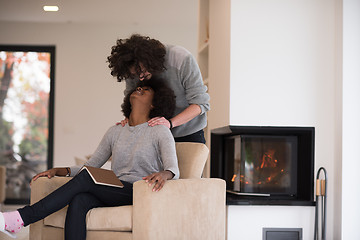 Image showing multiethnic couple hugging in front of fireplace