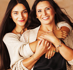 Image showing cute pretty teen daughter with mature mother hugging, fashion st