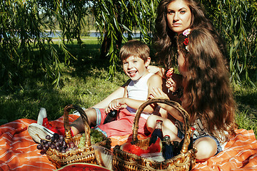 Image showing cute happy family on picnic laying on green grass mother and kid