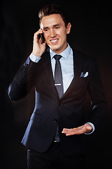 Image showing young pretty business man standing on black background, modern h