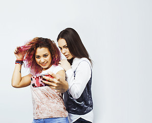 Image showing lifestyle people concept: two pretty stylish modern hipster teen girl having fun together, diverse nation mixed races, happy smiling making selfie 