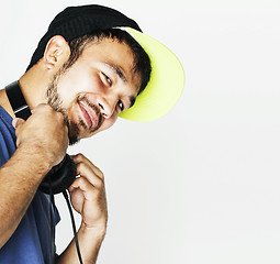 Image showing young asian man in hat and headphones listening music on white b