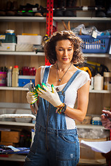 Image showing woman car mechanic in blue overalls declines hand gloves