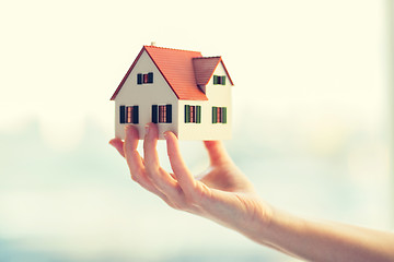 Image showing close up of hands holding house or home model