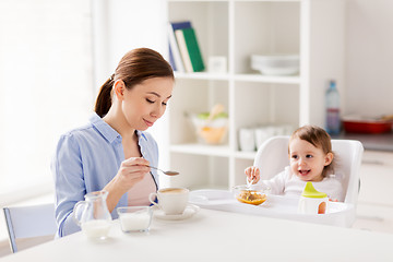 Image showing happy mother and baby having breakfast at home