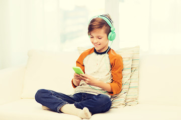 Image showing happy boy with smartphone and headphones at home