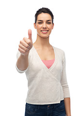 Image showing happy smiling woman with braces showing thumbs up