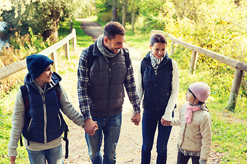 Image showing happy family with backpacks hiking in woods