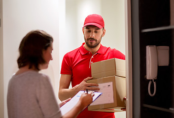 Image showing deliveryman and customer with parcel boxes at home