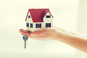 Image showing close up of hands holding house model and keys