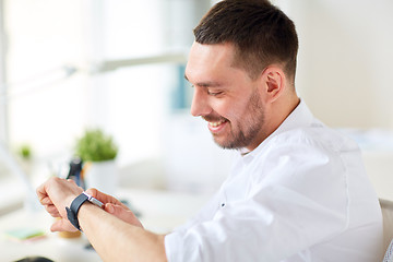 Image showing close up of businessman with smartwatch at office