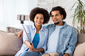 Image showing happy couple with smartphone taking selfie at home