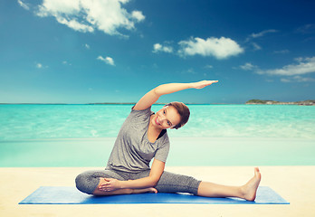 Image showing happy woman making yoga and stretching on mat