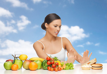 Image showing woman with fruits rejecting fast food