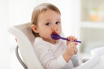 Image showing baby with spoon eating food at home