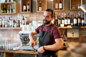 Image showing barista with holder and tamper making at coffee