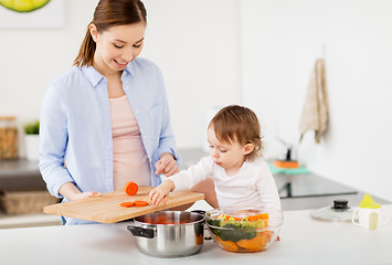 Image showing happy mother and baby cooking food at home kitchen