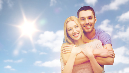 Image showing happy smiling couple hugging over sky and sun